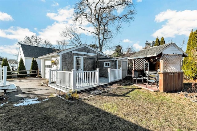 rear view of house with an outbuilding and a yard