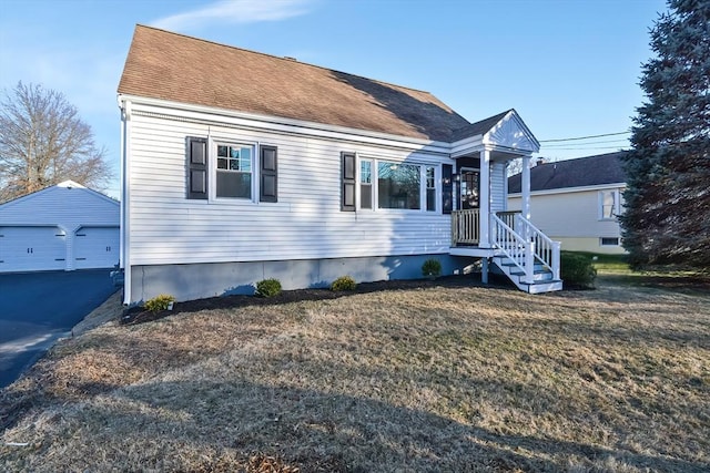 view of front facade featuring an outbuilding, a garage, and a front lawn