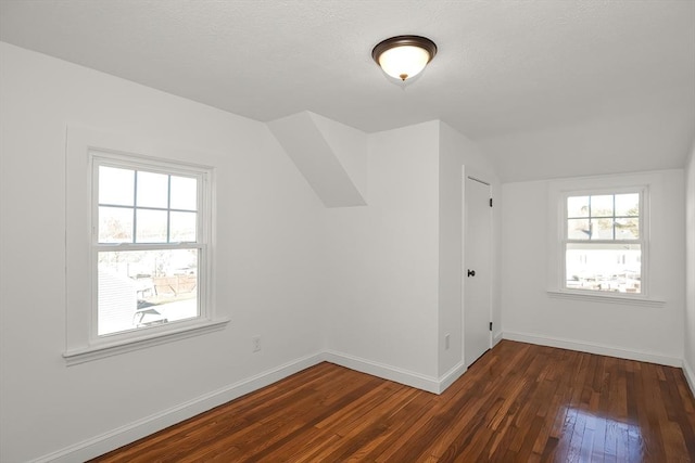 bonus room featuring dark wood-type flooring and vaulted ceiling