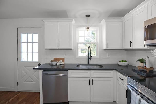 kitchen featuring white cabinets, pendant lighting, stainless steel appliances, and sink