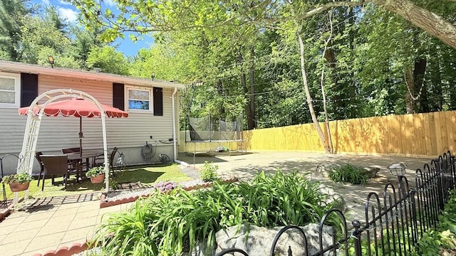 9 Willow Rd, Holbrook, MA 02343 - fenced backyard featuring a trampoline and a patio