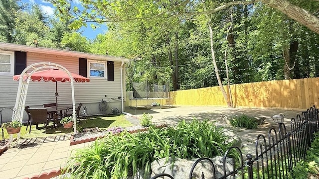 9 Willow Rd, Holbrook, MA 02343 - fenced backyard featuring a trampoline and a patio area