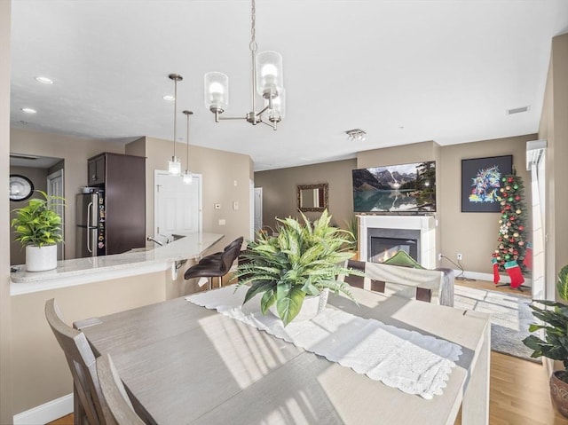 dining area featuring an inviting chandelier and light hardwood / wood-style flooring