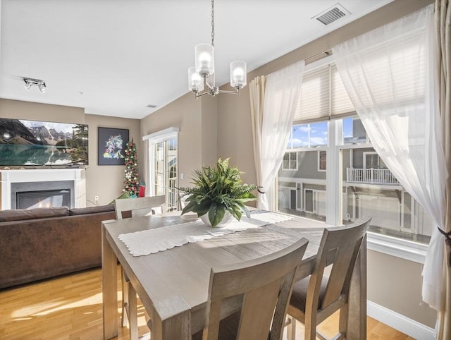 dining space featuring an inviting chandelier and light hardwood / wood-style floors