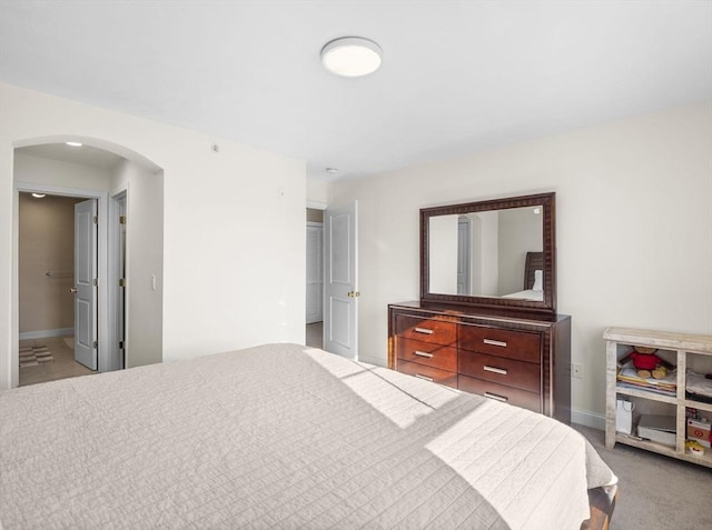 bedroom with light carpet and ensuite bath