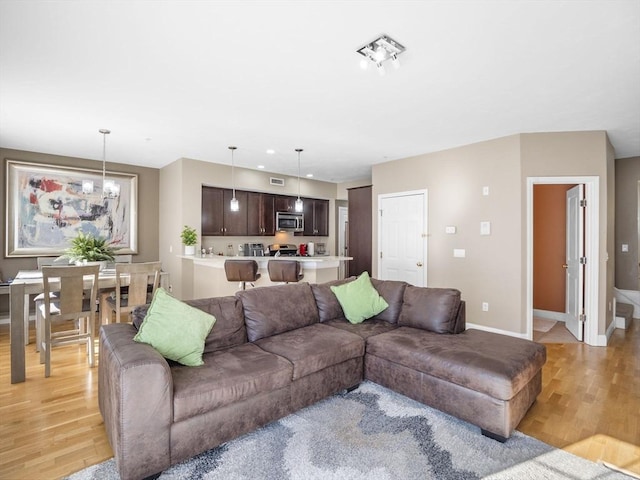 living room featuring an inviting chandelier and light wood-type flooring