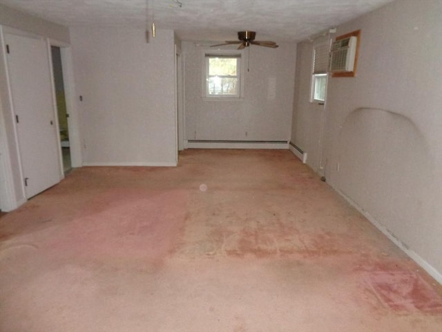 basement with ceiling fan, a baseboard heating unit, a textured ceiling, light carpet, and an AC wall unit