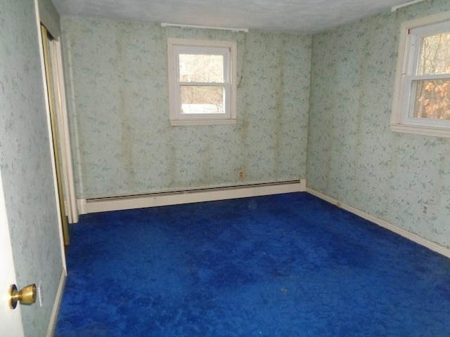 carpeted empty room with baseboard heating