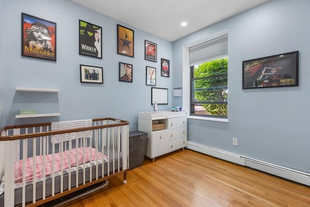 80 Beaumont St Unit 101, Boston, MA 02124 - bedroom with a baseboard heating unit, wood finished floors, a nursery area, and recessed lighting