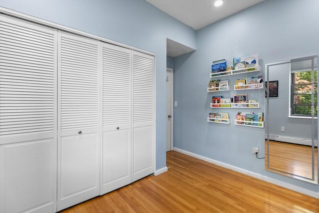 80 Beaumont St Unit 101, Boston, MA 02124 - unfurnished bedroom with baseboard heating, light wood-style floors, and a closet