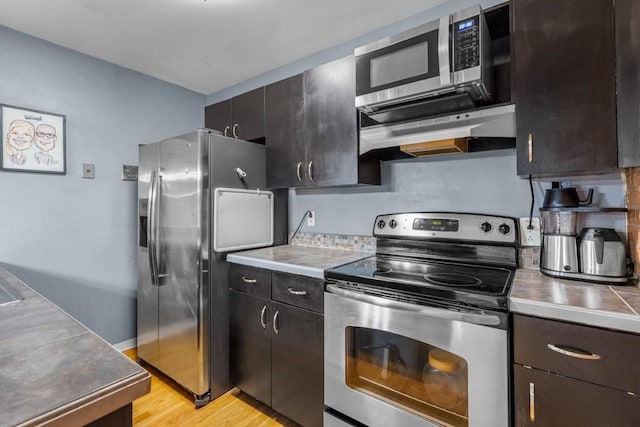 80 Beaumont St Unit 101, Boston, MA 02124 - kitchen featuring stainless steel appliances, light wood finished floors, under cabinet range hood, light countertops, and dark brown cabinets