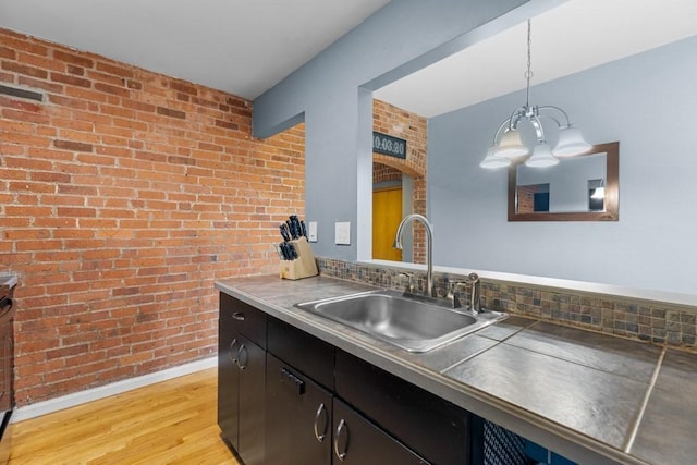 80 Beaumont St Unit 101, Boston, MA 02124 - kitchen featuring brick wall, a chandelier, light wood-style floors, and hanging light fixtures