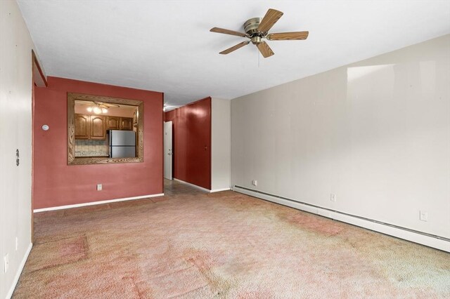 empty room with carpet floors, baseboards, a ceiling fan, and a baseboard heating unit