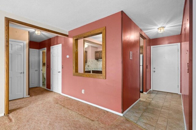 hall featuring baseboards and stone finish flooring