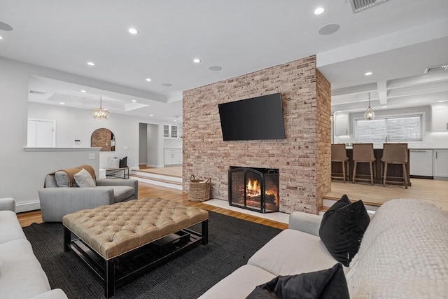 living area with recessed lighting, a fireplace, and light wood-style floors