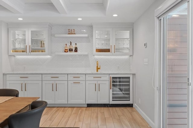 bar featuring wet bar, wine cooler, light wood-style floors, crown molding, and tasteful backsplash