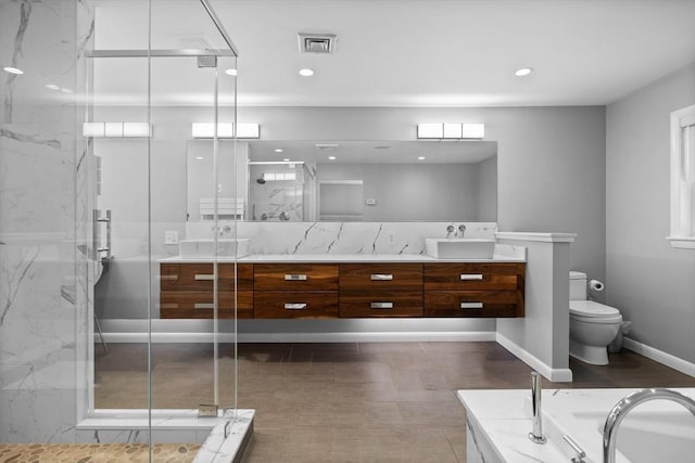 full bathroom with visible vents, a marble finish shower, double vanity, a sink, and toilet