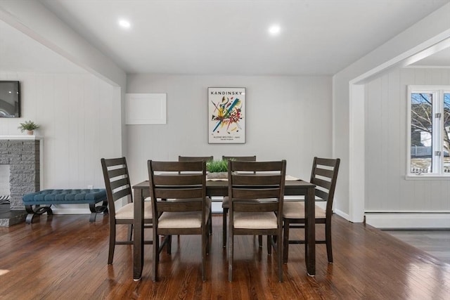 dining room with a fireplace, dark wood-type flooring, and baseboard heating