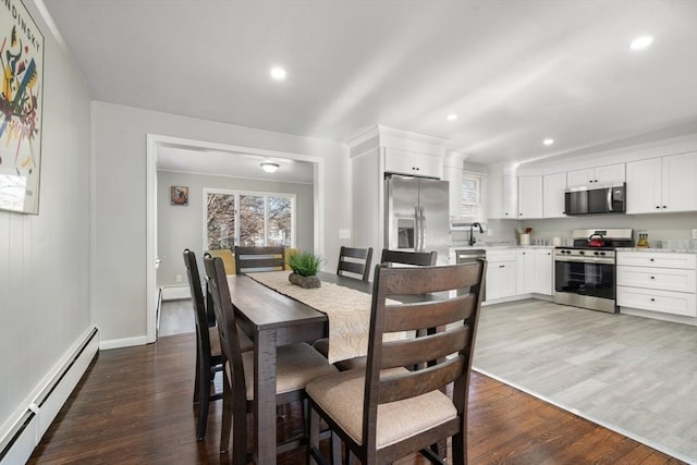 dining area with a baseboard radiator, sink, and dark hardwood / wood-style flooring