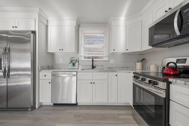 kitchen featuring stainless steel appliances, sink, and white cabinets