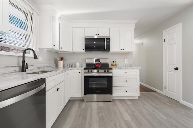 kitchen featuring white cabinetry, sink, light stone counters, and stainless steel appliances