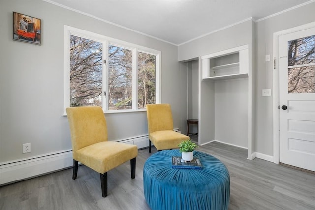 sitting room featuring hardwood / wood-style floors, crown molding, and a baseboard radiator