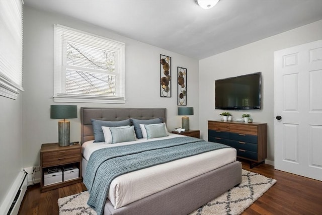 bedroom with baseboard heating and dark hardwood / wood-style floors