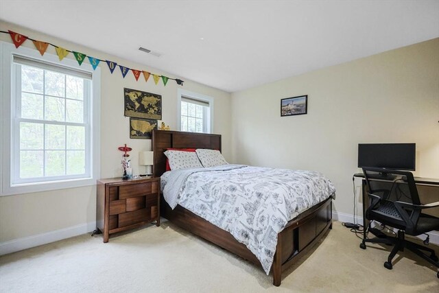 bedroom featuring baseboards, light carpet, and visible vents