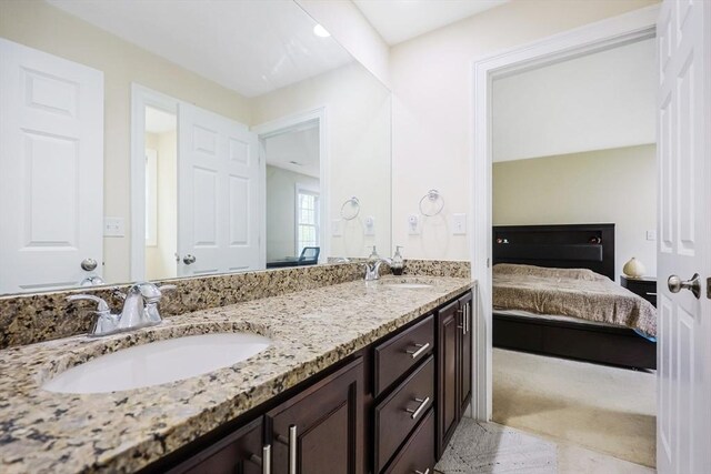 ensuite bathroom with double vanity, ensuite bathroom, and a sink