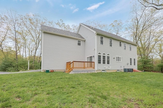 rear view of house featuring central air condition unit, a yard, and a deck