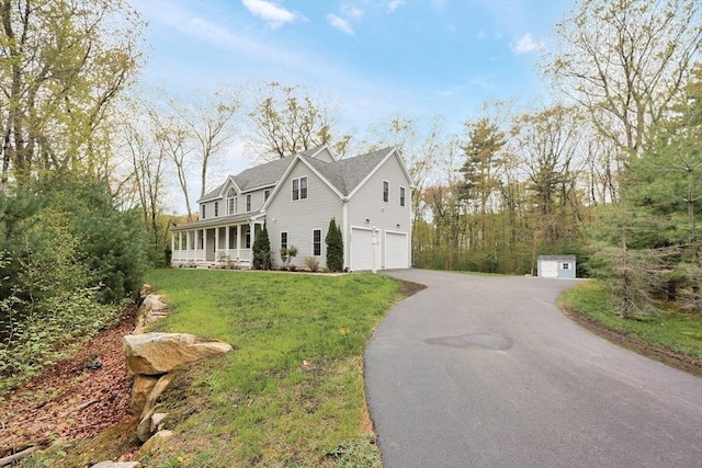 view of home's exterior with aphalt driveway, a sunroom, a garage, and a lawn
