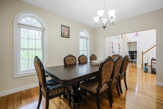 dining room with an inviting chandelier, light wood-type flooring, and baseboards