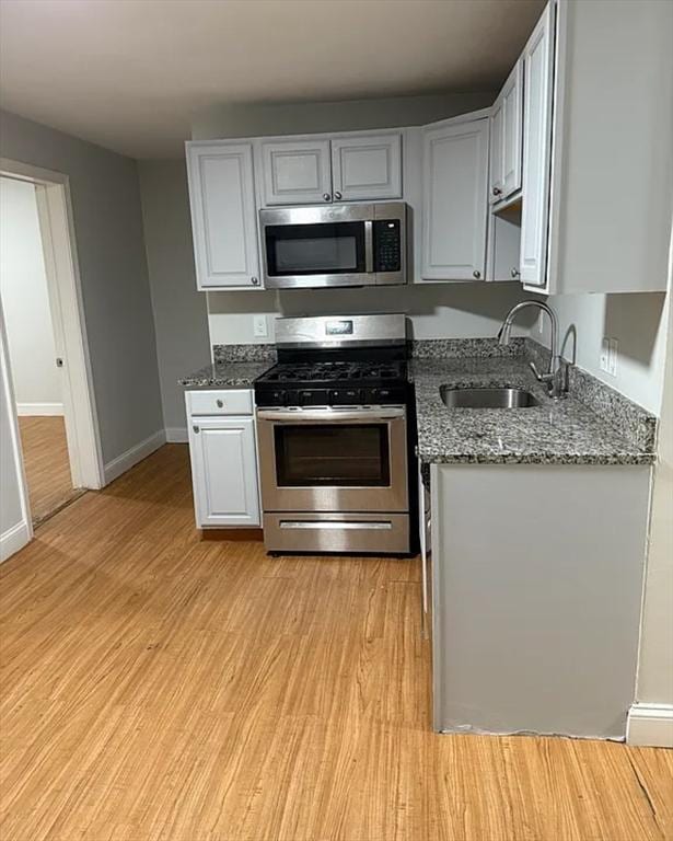 7 Esmond St, Boston, MA 02121 - kitchen with light wood-style flooring, a sink, stainless steel appliances, and stone countertops