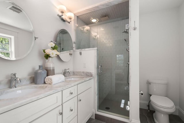 full bath featuring visible vents, a sink, double vanity, and a shower stall