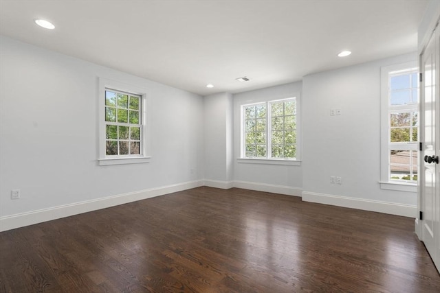 empty room featuring baseboards, recessed lighting, and dark wood-type flooring