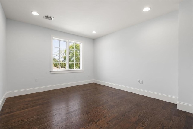 unfurnished room with visible vents, recessed lighting, baseboards, and dark wood-type flooring