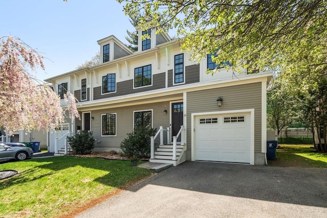 view of front of house featuring a garage, a front lawn, and driveway
