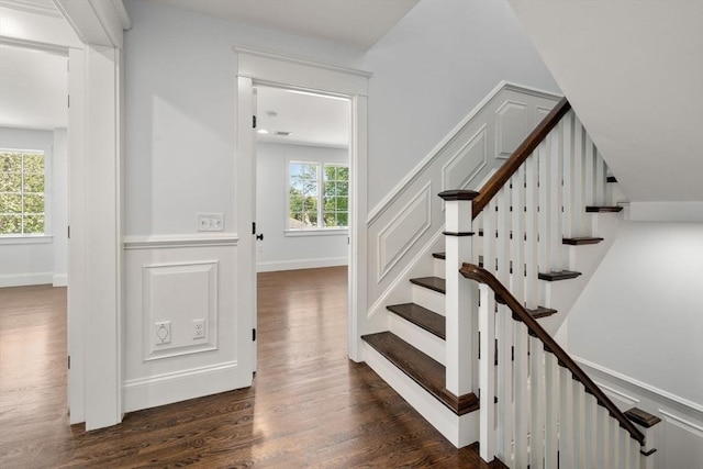 staircase with baseboards and wood finished floors