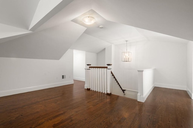 additional living space with baseboards, wood finished floors, and lofted ceiling