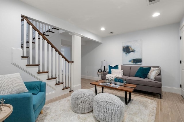living room with baseboards, light wood finished floors, recessed lighting, and visible vents