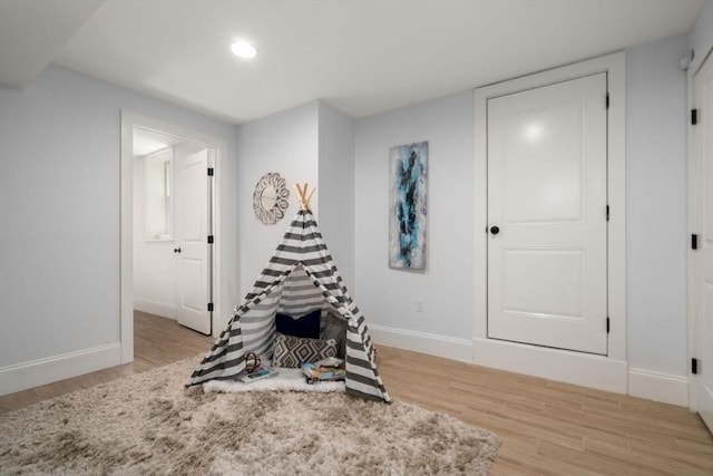 recreation room featuring baseboards, recessed lighting, and light wood finished floors