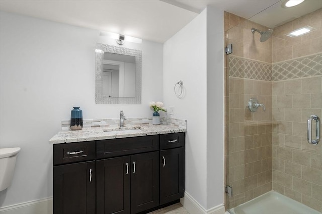 bathroom with vanity, toilet, baseboards, decorative backsplash, and a shower stall