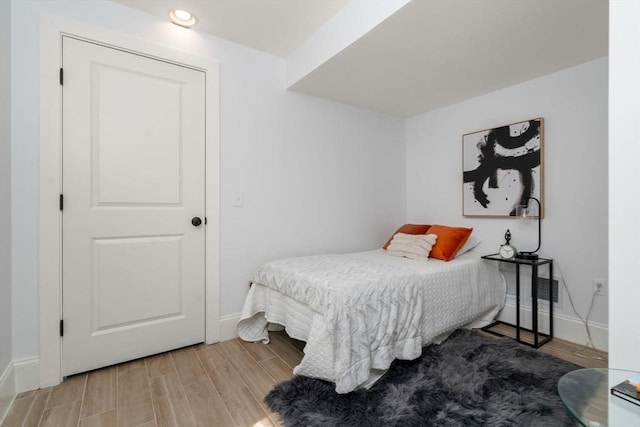 bedroom with baseboards, recessed lighting, and wood finished floors