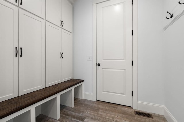 mudroom with visible vents, baseboards, and wood finished floors