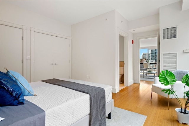 bedroom featuring light hardwood / wood-style flooring and ensuite bathroom