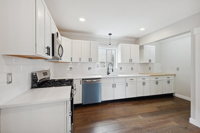 kitchen with dark wood-style floors, white cabinetry, stainless steel appliances, and a sink