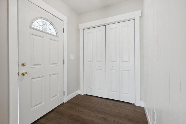 foyer entrance with dark wood-style floors and baseboards