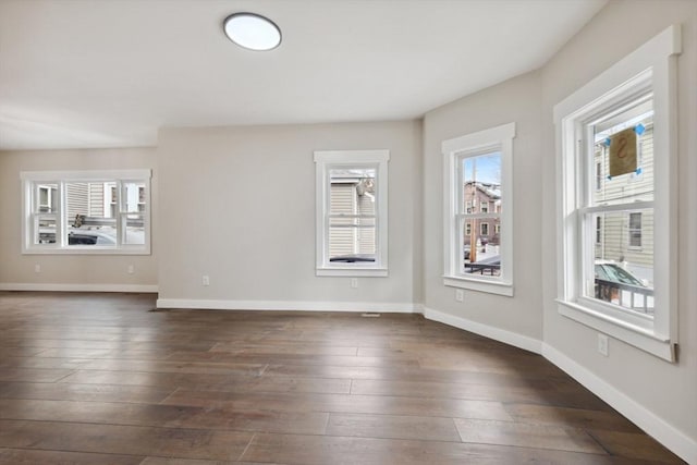 unfurnished living room featuring dark wood finished floors and baseboards