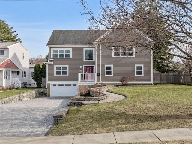 83 Altamont Ave, Melrose, MA 02176 - view of front of home with a front lawn, decorative driveway, fence, and a garage