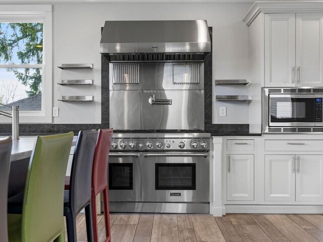 83 Altamont Ave, Melrose, MA 02176 - kitchen featuring stainless steel appliances, tasteful backsplash, open shelves, light wood-type flooring, and white cabinetry